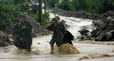 圖為救援官兵冒雨參與抗洪搶險(xiǎn)。